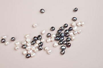 Black and white pearl on pastel background top view. Natural freshwater pearls