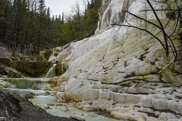 Fototapeta na wymiar Hot springs at Bagni San Filippo, with calcium carbonate deposits surrounding the thermal water