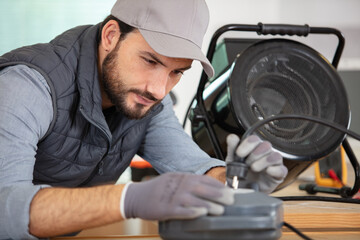 young man repairing appliance in workshop