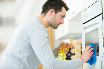man thorough cleaning the oven