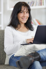 smiling senior woman using laptop at home