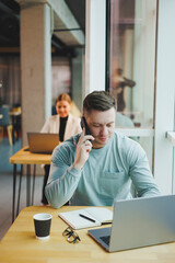 Obraz premium Successful businessman leader thinking about future corporate success plan ideas, sitting at office desk with laptop, looking at panoramic window of modern corporation building.