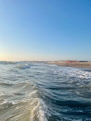 Blue color sea waves with white foam. Marine beach background