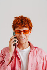 Young ginger man wearing shirt talking on cellphone