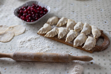 Fototapeta na wymiar Homemade raw dumplings with cherries. Cooking at home. Selective focus.