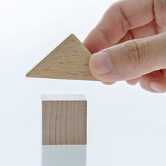 Man hand building house with toy blocks