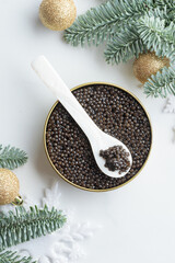 Black caviar in a mother-of-pearl spoon with Christmas decoration