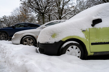 Cars covered with fresh white snow on a cold winter day.