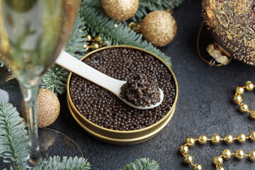 Black caviar in a mother-of-pearl spoon with Christmas decoration