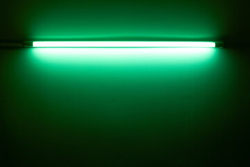 Green neon lamp on a white wall