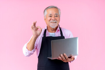 senior person wear apron with laptop