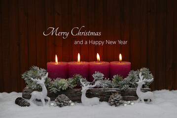 Christmas and New Year greetings: Four red candles decorated with fir greenery and Christmas decorations. Merry Christmas and a Happy New Year.