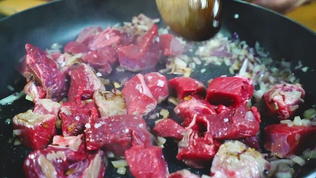 Dorando carne de ternera en una sart&eacute;n con algunas verduras