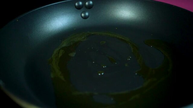 Echando cebolla en una sarten con una espatula y la mano