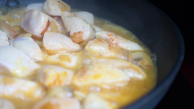 Pollo al curry cocin&aacute;ndose l&eacute;ntamente en una sart&eacute;n