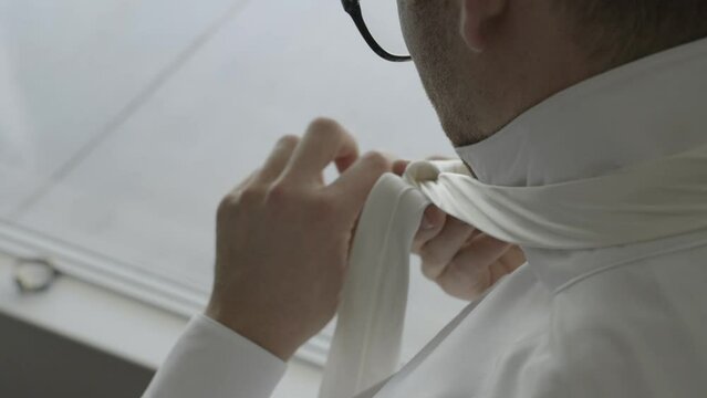 Groom tying his tie. Groom getting ready on his wedding day. Shot in 4K 60FPS for high quality slow motion. To purchase entire event raw at wholesale price email willneatheryyahoo.com.