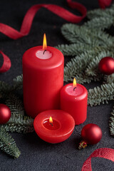 Red candles on dark background with christmas decoration