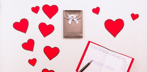 Composition romantique de la Saint-Valentin, déclaration d'amour, fête des mères, anniversaire, fiançailles. Cœurs rouges avec un agenda ouvert à la date du 14 février.