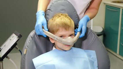 Nitrous oxide in dental clinic while treating young patients with milk teeth. Relaxation of patient before surgical or dental procedures. Child lying in dental chair with inhalation sedation. 4 k