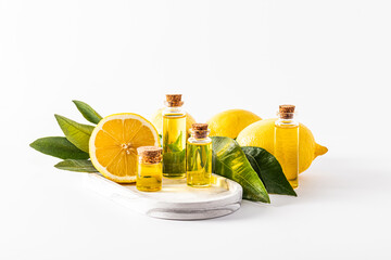 a set of glass bottles with a cork with a product based on lemon essential oil stand on a white...