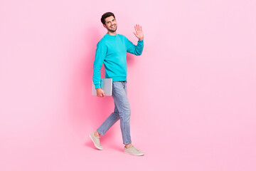 Full body photo of handsome young man hold netbook walking wave arm dressed stylish blue garment...
