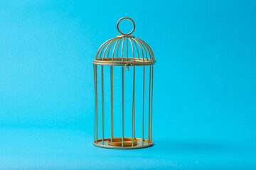 Closed golden cage on a blue background. The concept of change. Comfort zone. Fear of the new.