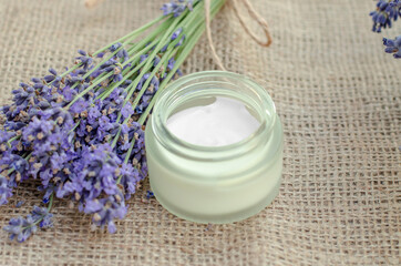 Obraz na płótnie Canvas Jar of body cream and fresh lavender flowers. Open jar of lavender moisturizer