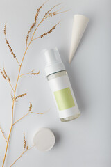 Cosmetics mock up template, bottle of washing foam with blank label, concrete decor on white background. Face skin care cleanser, flatlay