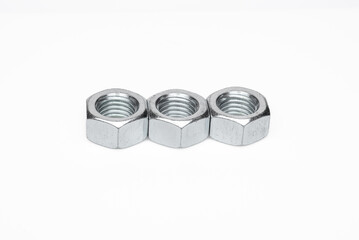 Set of steel nuts. On an isolated white background. With scratches. Close-up studio macro photography.