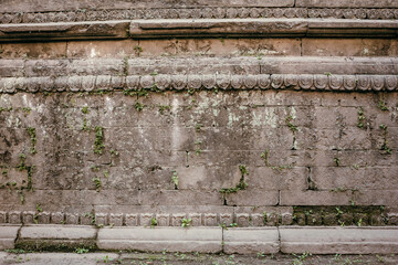 Frontal view of a grey, antique temple wall with ornaments and engravings in Nepal. Empty scene as background with copy space