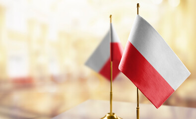 Small flags of the Poland on an abstract blurry background