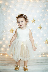 cute baby girl in a white and gold dress