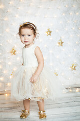 cute baby girl in a white and gold dress