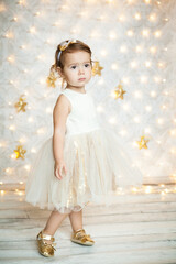 cute baby girl in a white and gold dress