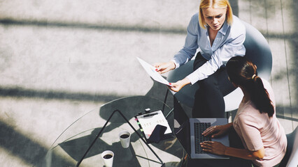 Businesswomen discussing paperwork