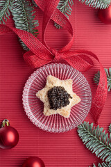 Black caviar appetizers bread star on a christmas decorated red background