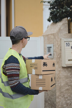 Young Student Delivering Packages, Ringing The Doorbell Of A House. Precarious First Job Concept.