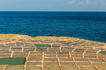 Traditional salt pans in Xwejni Bay on the beach of island of Gozo, Malta.