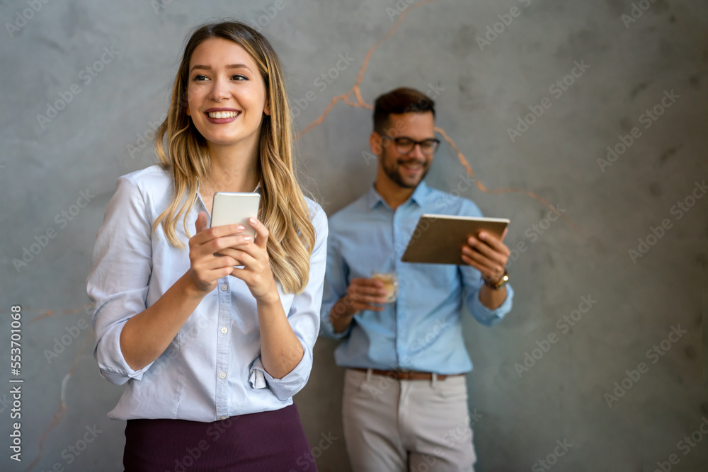 Wall mural Happy businesswoman using mobile phone while analyzing weekly schedule in corporate office