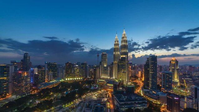 Time lapse: Aerial cityscape view during dawn overlooking the Kuala Lumpur and construction area at sunrise in Malaysia. Night to day. Prores 4K DCI Timelapse.