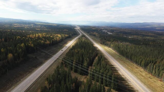 Breathtaking boundless vastness of the Yellowhead Highway 5 in Alberta , Canada. On a partially cloudy day in the fall Cars and Trucks driving on the Road