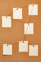 Blank paper notes are pinned to a cork board. The concept of detective investigation. Copy space.