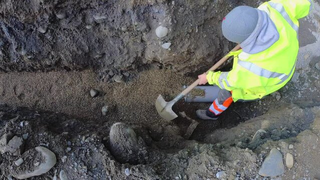Shovelling gravel on a construction site to protect a drainage pipe, High quality 4k footage