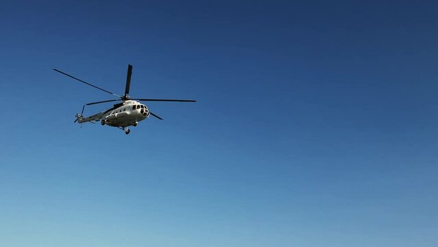 The helicopter flies in the sky. Close up helicopter over the sea.