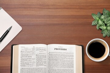 Holy Bible book and coffee cup on table.