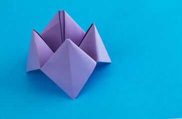 Origami paper fortune on blue background