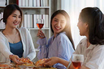 Friends at birthday party clinking glasses with champagne and pizza, enjoying Christmas vacation, pizza on the table. Holiday Party event