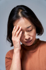 Fototapeta premium Mature Asian woman having a headache