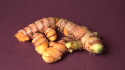 Turmeric powder in wooden bowl and fresh turmeric root on textured background. Herbs are native ,Food and drink, diet nutrition, health care concept.