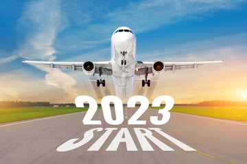 Inscription on the runway start 2023 surface of the airport road line rapidly taking off aircraft....